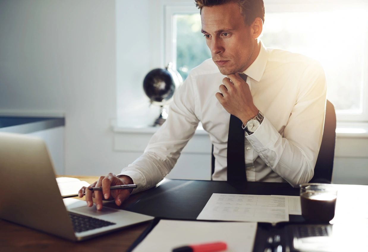 A man sitting at a table with his laptop.